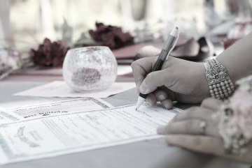 Photo of a hand signing a wedding license